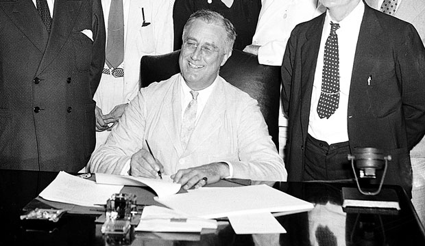 President Franklin D. Roosevelt signs the Social Security Act in Washington, D.C., on August 14, 1935. (AP)