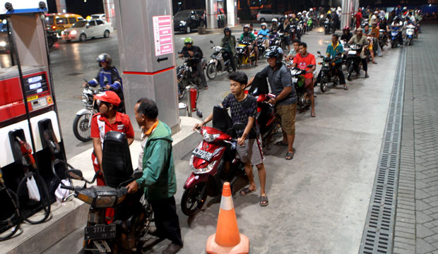 Motorists in Indonesia line up at a gas station before the fuel-price hike takes effect in June 2013. (AP/Trisnadi)
