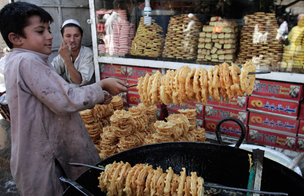 A boy makes traditional sweets at a market in Kabul, Afghanistan. (AP/Rahmat Gul)