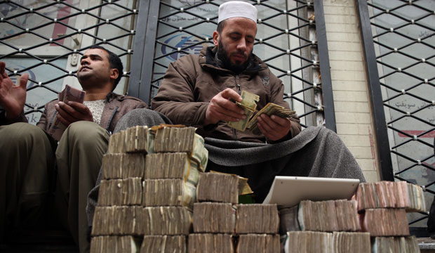 A man counts money at a Kabul market in Afghanistan. (AP/Massoud Hossaini)