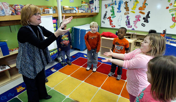 West Amory Elementary School teacher Mary Sanderson, left, and her pre-K students play a color game with a orange beanbag in Amory, Mississippi. (AP/Rogelio V. Solis)