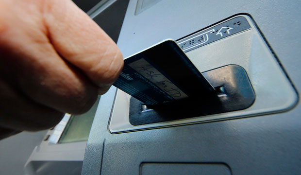 A person inserts a debit card into an ATM in Pittsburgh on January 5, 2013. (AP/Gene J. Puskar)