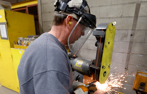 A workers grinds parts used to build fans for industrial ventilation systems at the Robinson Fans Inc. plant in Harmony, Pennsylvania. (AP/Keith Srakocic)