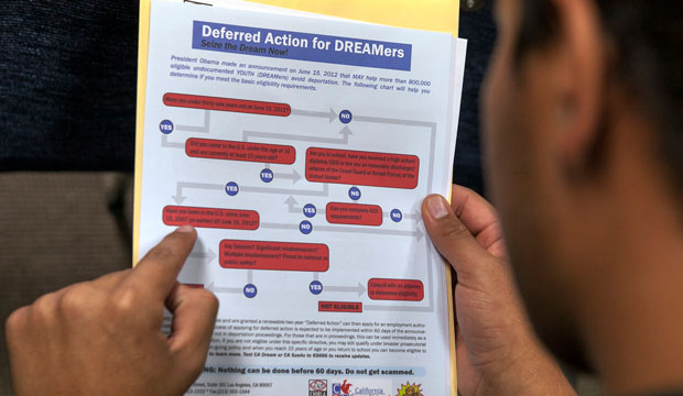 A legal immigrant reads a guide of the conditions needed to apply for the Deferred Action for Childhood Arrivals, or DACA, program. (AP/Damian Dovarganes)
