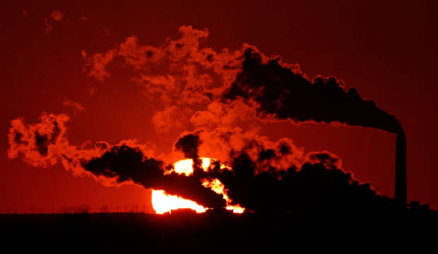 Steam from the Jeffrey Energy Center, a coal-fired power plant, is silhouetted against the setting sun near St. Marys, Kansas, on March 8, 2014. (AP/Charlie Riedel)