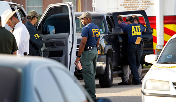 Investigators for the Federal Bureau of Investigation and the Bureau of Alcohol, Tobacco, Firearms and Explosives are pictured outside a house in DeSoto, Texas, after a shooting, August 2013. (The Dallas Morning News/Kye R. Lee)