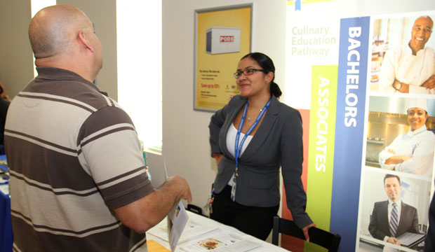A representative from the Le Cordon Bleu College of Culinary Arts speaks with a prospective student at an education fair. (Flickr/usag-miami)