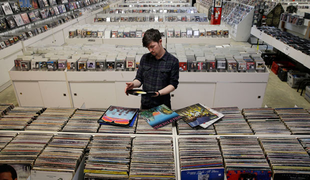 Store employee Josh Kelly checks the condition of used records at Vintage Vinyl Records on April 14, 2015. (AP/Mel Evans)