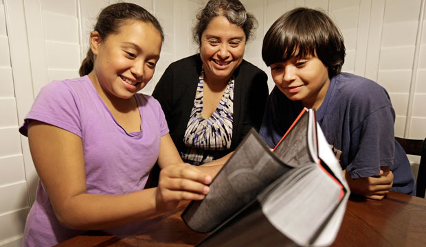 Rosaisela Rodriguez, center, reads with her children Isabel Gutierrez, left, and Rafael Gutierrez, at their home in Pleasant Hill, California on November 10, 2014. (AP/Ben Margot)