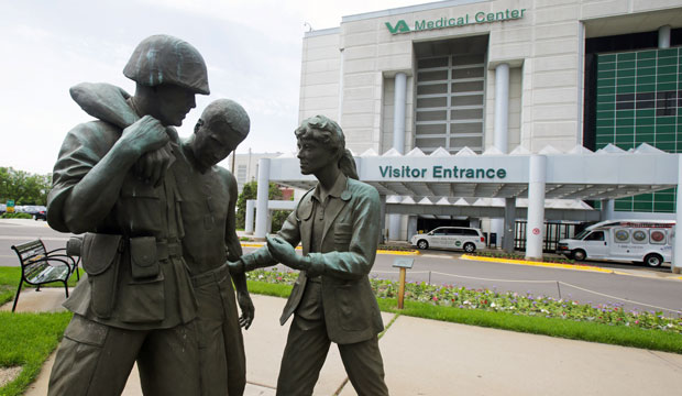 A sculpture portrays a wounded soldier being helped on the grounds of a Veterans Affairs hospital, June 9, 2014. (AP/Jim Mone)