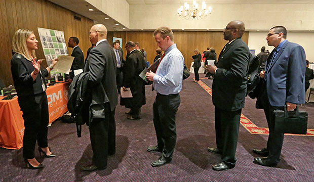 A corporate recruiter speaks with job applicants during a job fair in Chicago, April 2015. (AP/M. Spencer Green)