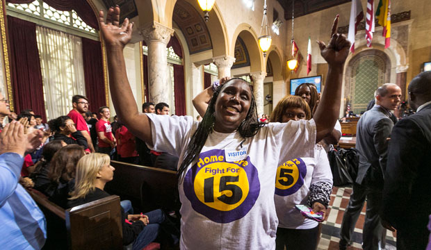 Workers react as the Los Angeles City Council, in a preliminary vote, approves a measure to raise the minimum wage to $15 an hour by 2020, June 2015. (AP/Damian Dovarganes)