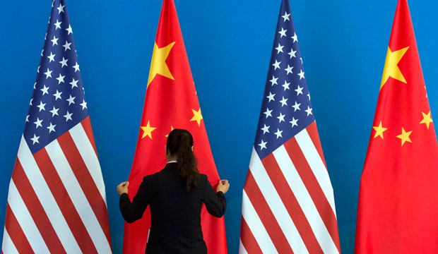 A Chinese woman adjusts the Chinese and American flags before a U.S.-China Strategic and Economic Dialogue meeting in Beijing on July 10, 2014. (AP/Ng Han Guan)