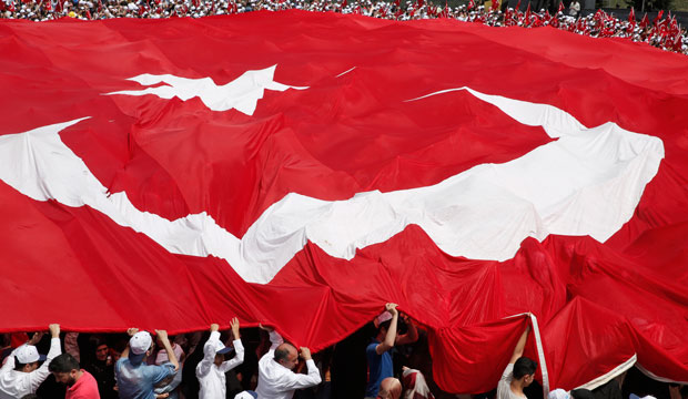 People carry a huge Turkish flag during a local municipality event in Istanbul on May 16, 2015. (AP/Lefteris Pitarakis)