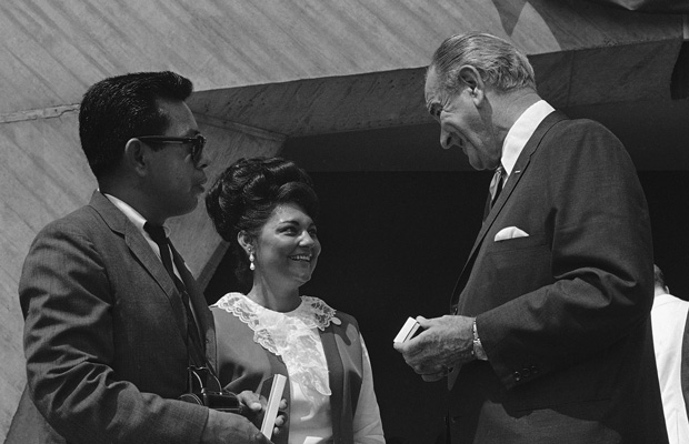 President Lyndon B. Johnson presents a souvenir pen to Mr. and Mrs. Lupe Arzola during the signing of the Fair Housing Act in Washington, August 1968. (AP)