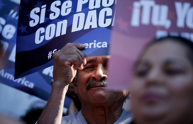 A man stands among signs during a rally in San Diego in support of immigration reform. (AP/Gregory Bull)