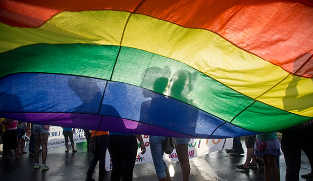 Members of the LGBT movement hold a gay pride flag as they attend a march to mark the International Day Against Homophobia in Managua, Nicaragua, May 17, 2015. (AP/Esteban Felix)