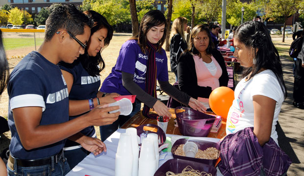 Members of the Normandale Community College Latino Club chat with a young girl, September 2012. (AP/Craig Lassig)