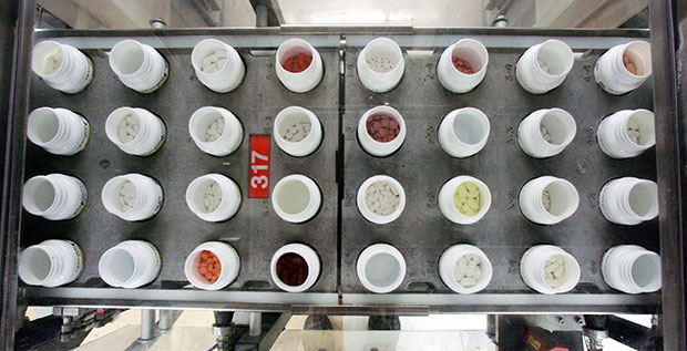 Bottles of prescription medications move along a production line at a dispensing pharmacy, February 2006. (AP/Mel Evans)