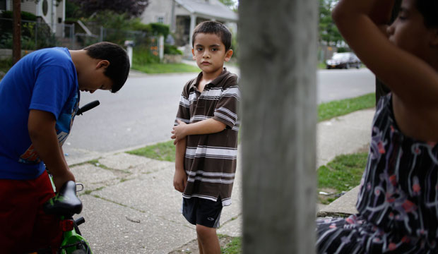 Kevin Torres, age 7, who arrived in the United States unaccompanied from El Salvador, plays with neighbors outside his apartment building in Huntington Station, New York, in 2014. (AP/Seth Wenig)