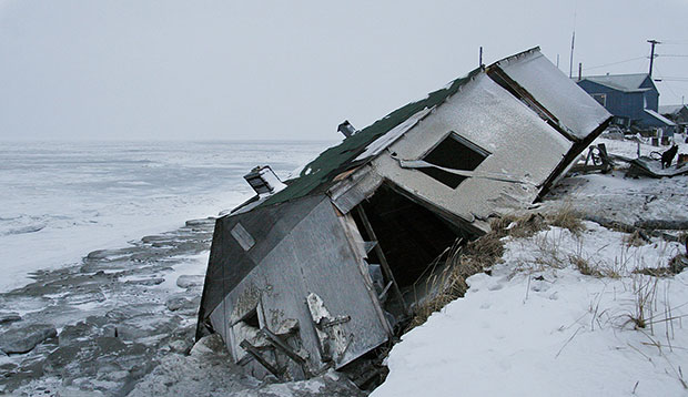 An abandoned house at the west end of Shishmaref, Alaska, sits on the beach after sliding off during a fall 2005 storm, December 2006. (AP/Diana Haecker)