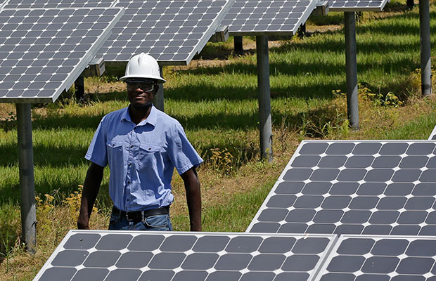 A power generation engineer walks beside solar panels, May 13, 2015. (AP/John Raoux)