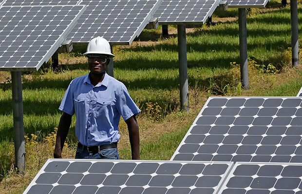A power generation engineer walks beside solar panels, May 13, 2015. (AP/John Raoux)