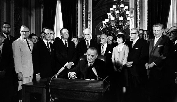 President Lyndon B. Johnson signs the Voting Rights Act of 1965 in a ceremony in the President's Room near the Senate Chambers on Capitol Hill in Washington, August 6, 1965. (AP)