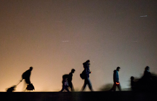 Migrants walk toward a checkpoint along the railway tracks near the border between Hungary and Serbia on September 13, 2015. (AP/Balazs Mohai)