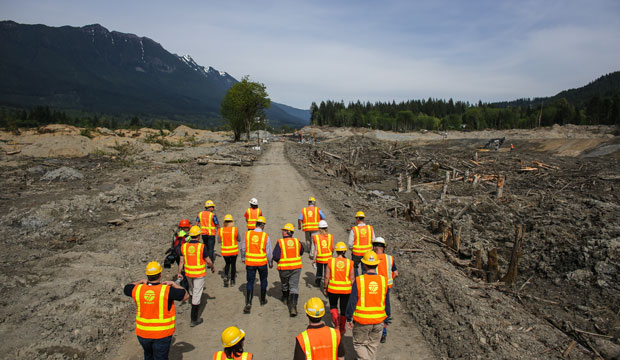 Officials walk into the debris field as Washington State Gov. Jay Inslee checks on progress at the site of the Oso mudslide on May 15, 2014 in Oso, Washington. (AP Photo/Seattlepi.com, Josh Trujillo)