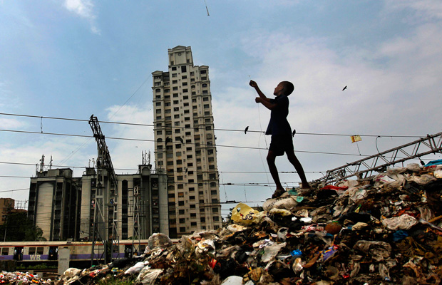 A young boy flies a kite on a garbage heap in Mumbai, India. (AP/Rafiq Maqbool)