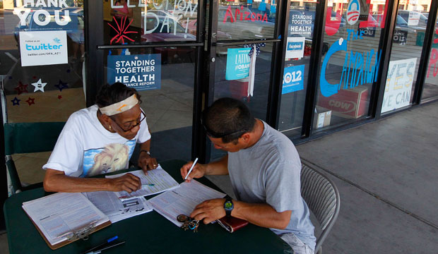 Campaign volunteer Vergie Morris, left, registers Valentin Navarro to vote on June 29, 2012, in Phoenix. (AP/Ross D. Franklin)