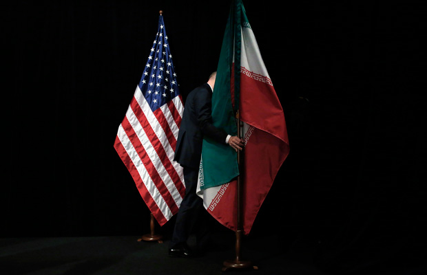 A staff member removes flags from the stage during the Iran nuclear talks in Vienna, Austria, July 14, 2015. (AP/Carlos Barria)