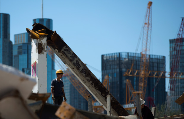 A worker stands on the site of a new development project at the central business district of Beijing, China, in June 2015. (AP/Andy Wong)