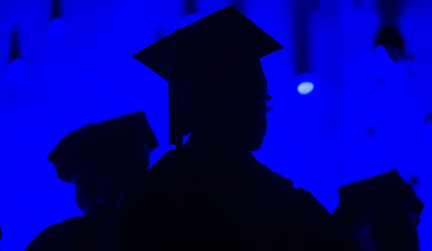 Members of the graduating class and faculty attend a college commencement on May 31, 2014. (AP/John Amis)