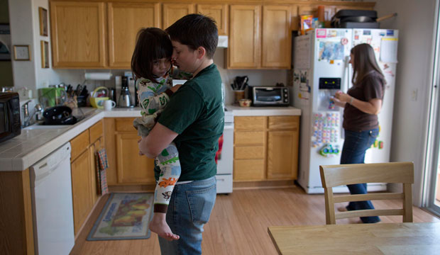 Sara Geiger holds her 3-year-old daughter as Geiger's partner prepares breakfast in Las Vegas, Nevada on April 16, 2013. (AP/Julie Jacobson)