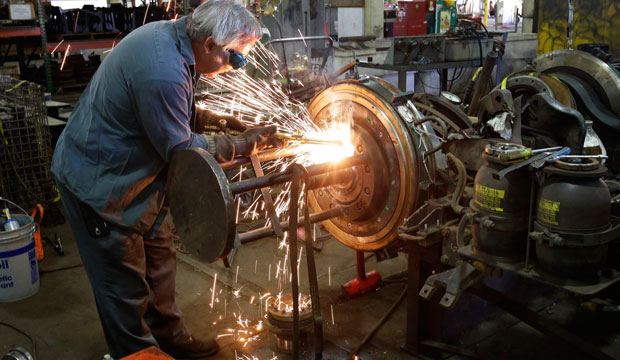 Light rail repairer Jack Egan works on railcar wheels at the Massachusetts Bay Transportation Authority's Riverside Maintenance Facility in Newton, Massachusetts in June 2015. (AP/Steven Senne)