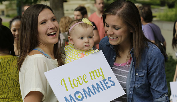 A married couple is pictured with their infant daughter, July 2014. (AP/Rick Bowmer)