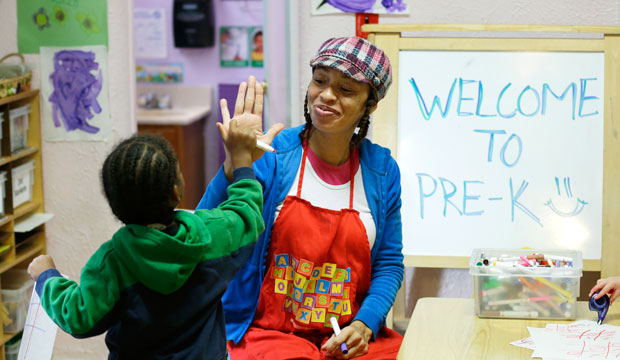 A teacher in a pre-K class gives a high-five, October 2014. (AP/Ted S. Warren)