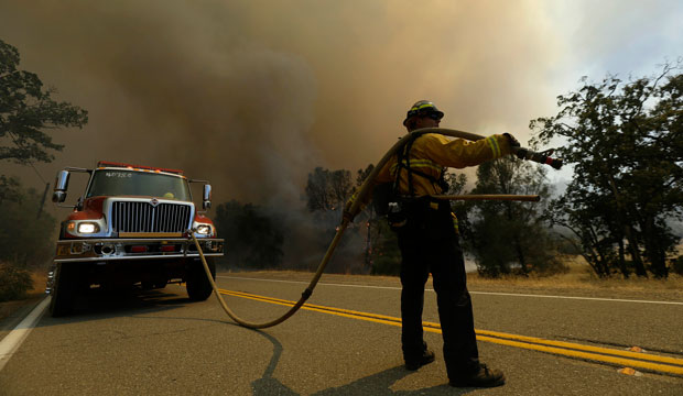 A firefighter watches a fire burn along Morgan Valley Road near Lower Lake, California, on August 13, 2015. (AP/Jeff Chiu)