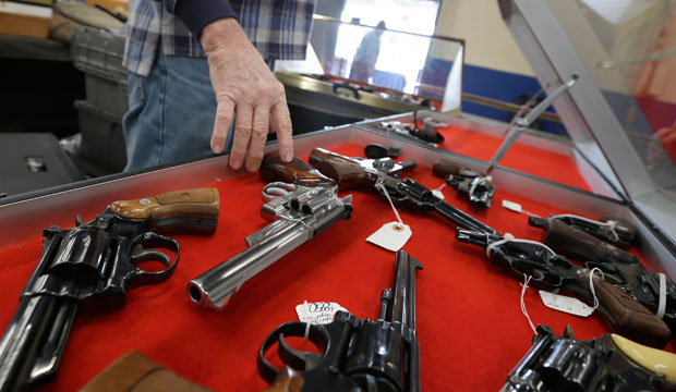 A dealer arranges handguns in a display case at the Arkansas State Fairgrounds in Little Rock on February 6, 2015. (AP/Danny Johnston)