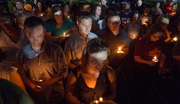 People attend a candlelight vigil in front of the WDBJ-TV station in Roanoke, Virginia, August 27, 2015, a day after reporter Alison Parker and cameraman Adam Ward from the station were killed during a live broadcast. (AP/Don Petersen)