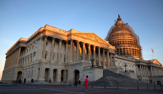 A jogger runs past the the U.S. Capitol at sunrise on October 22, 2015. (AP/Jacquelyn Martin)