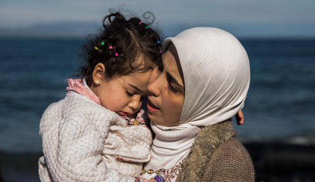 A Syrian mother hugs her child after arriving at the Greek island of Lesbos on an overcrowded inflatable boat on October 27, 2015. (AP/Santi Palacios)