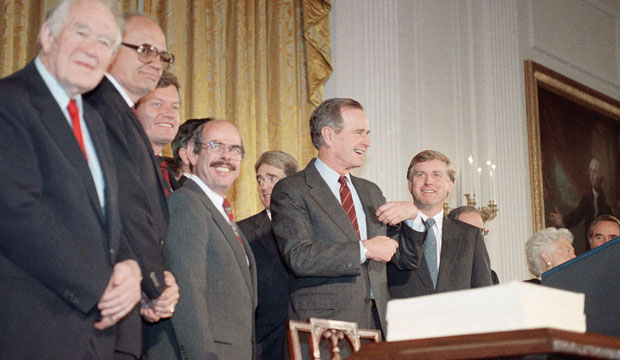President George H.W. Bush gestures after he signed the Clean Air Act of 1990, on November 15, 1990 in the East Room of the White House in Washington. (AP/Charles Tasnadi)
