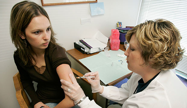 A student gets a mumps immunization shot from a nurse during a clinic at her university student health center in Des Moines, Iowa, 2006. (AP/Charlie Neibergall)