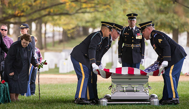 Service members lay an American flag on the casket of a soldier on October 26, 2015. (AP/Andrew Harnik)