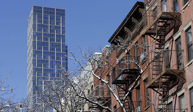 A luxury rental building rises high above other residential buildings in the East Harlem section of New York City, February 3, 2015. (AP/Seth Wenig)