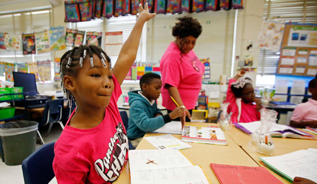 A second-grader eagerly asks to be called on in a language arts class, October 2015. (AP/Rogelio V. Solis)