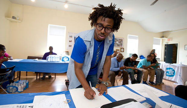 AmeriCorps volunteer John Harris III helps coordinate a jobs fair program for job seekers in Washington on July 31, 2013. (AP/Manuel Balce Ceneta)